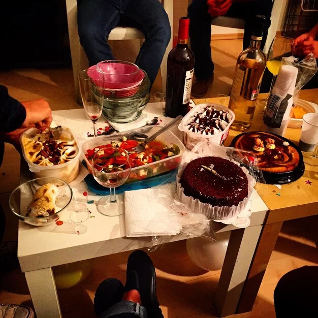 A family enjoying a birthday cake celebration after their adventure in a murder mystery-themed room.